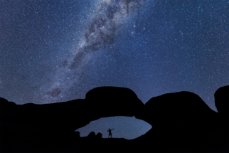 Spitzkoppe Namibia Single person in arch with stars and milkway.