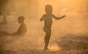 Dancing Himba child in the winter dust, Namibia