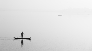 Rural boatman on a still morning, Myanmar