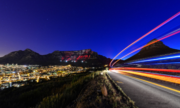 Car light trails Lions Head with Table Mountain background