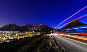 Car light trails Lions Head with Table Mountain background
